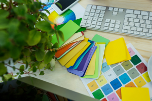 Color swatches and palette samples on a designer’s desk beside a keyboard.