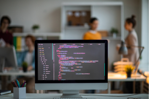 Computer screen displaying code in a modern office workspace.